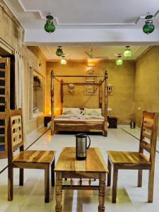 斋沙默尔金万寿菊酒店的一间设有两把椅子、一张床和两张桌子的房间