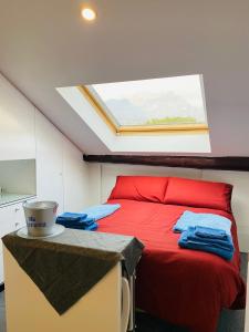 莱科Lecco Centro 1的一间卧室配有一张红色的床和天窗