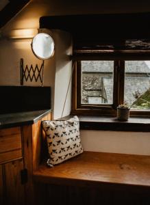 巴恩斯特珀尔Holwell Holistic Retreat的一间设有窗户和台面枕头的房间