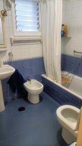 阿罗纳Sunny-Harbour的蓝色瓷砖浴室设有卫生间和水槽