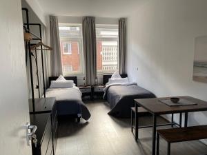 不莱梅Apartment an der Weserpromenade - Schlachte - Parkplätze的客房设有两张床、一张桌子和一扇窗户。
