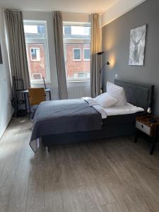 不莱梅Apartment an der Weserpromenade - Schlachte - Parkplätze的一间卧室设有一张床和两个窗户。