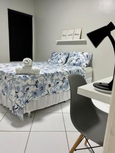 博阿维斯塔Apartamento em Boa Vista的一间卧室配有一张床、一张桌子和一把椅子