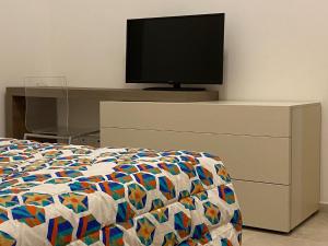 锡耶纳L'angolo di Costalpino的一间卧室配有一张床,梳妆台上配有电视