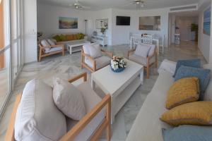 伊斯兰蒂拉Apartamentos Las Americas的带沙发和椅子的客厅以及客厅。