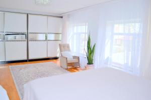 巴库Garden Cottage near Beach, Airport的白色卧室配有白色的床和椅子