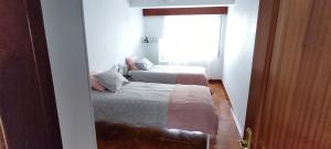 卡马里尼亚斯alecrin的一间小卧室,配有两张床和窗户