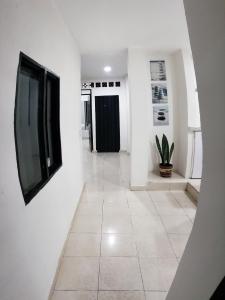 伊瓦格Mapalay House的走廊上设有白色的墙壁和墙上的电视
