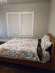 圣安东尼奥Luxurious 3 bedroom near downtown的一间卧室配有一张带被子的床和两个窗户