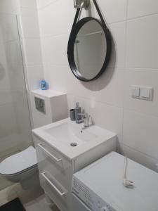 莱什诺Good Time Apartaments Sienkiewicza的白色的浴室设有水槽和镜子