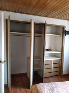 波哥大Mirador del parque的一间卧室配有带架子的衣柜和一张床