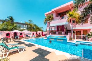 珀拉什奇亚Miramar Suites的粉红色建筑前的游泳池