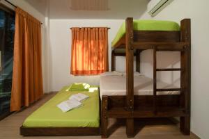 科韦尼亚斯Hotel Zabdi的客房配有两张双层床和绿色床垫。