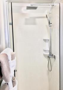 亚历山德拉杏仁阁汽车旅馆的墙上设有白色毛巾和淋浴的浴室