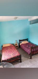圣萨尔瓦多德朱Lo de Margarita的蓝色墙壁客房的两张床