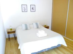门多萨Buenaventura Apartment的一张白色的床,位于带镜子的房间里