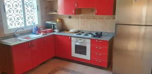 乌季达Villa sur le golf d'Oujda avec piscine privée的一间带红色橱柜和冰箱的小厨房