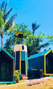 曼巴豪Lanzones Cabana的一座灯塔,位于一座棕榈树建筑旁边