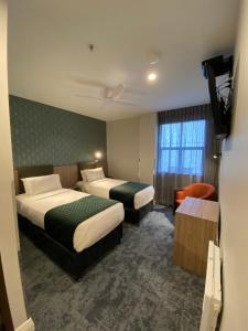 惠灵顿奇尼迪酒店的酒店客房设有两张床和电视。