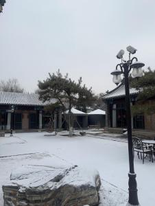 承德承德开仁华府酒店（避暑山庄店）的建筑物旁边的一根轻极,上面有雪