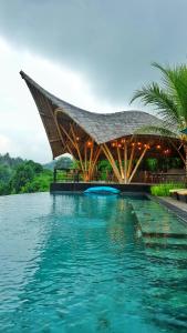 乌布Kadewa Retreat Ubud - Adults Only的一座游泳池,上面有一座大型水面建筑