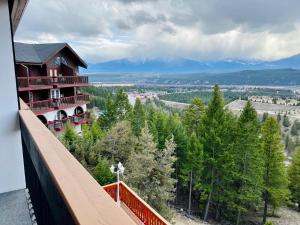 镭温泉Rocky Mountain Springs Lodge的从树木繁茂的建筑的阳台上可欣赏到风景