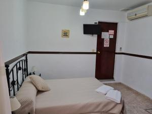 塞维利亚哈维尔膳食公寓的一间卧室设有一张床和一个小门