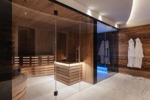 科尔福索加尼拉多拉达公寓式酒店的浴室设有玻璃淋浴间和木墙