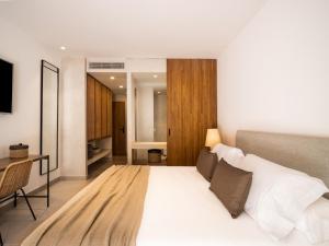 萨阿拉德洛斯阿图内斯Hotel Porfirio Picota - Adults Recommended的卧室配有一张白色大床和一张书桌
