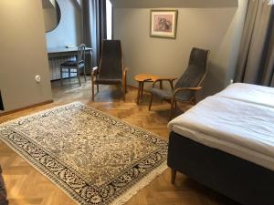 博里霍尔姆Guntorps Herrgård的一间卧室配有一张床铺、椅子和一张桌子