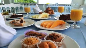 伊斯基亚奥巴特瑞酒店的一张桌子,上面放着甜点盘和橙汁