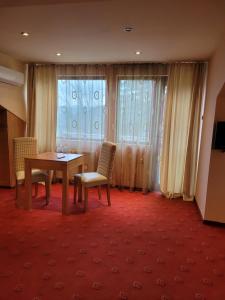 特里亚夫纳布拉斯言大厦酒店的客房设有桌子、两把椅子和窗户。