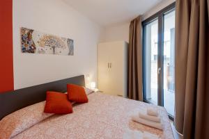 圣托·斯特凡诺·阿尔马尔Aregai Marina Exclusive Seaside Apartments的一间卧室配有带橙色枕头的床和窗户。
