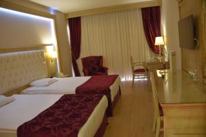伊兹密尔依歌帕拉斯酒店的酒店客房,配有两张床和椅子