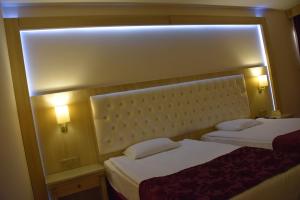 伊兹密尔依歌帕拉斯酒店的配有2盏灯的酒店客房的2张床