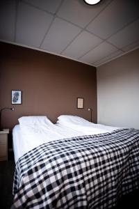 AskAskvoll Fjordhotell的一间卧室配有一张床,床上有条毯子