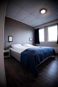 AskAskvoll Fjordhotell的一间卧室配有一张带蓝色毯子的大床