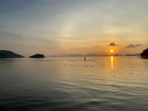 阁遥岛可雅海景山林小屋的日落时站在水面上的人