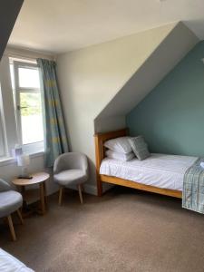 West TarbertWest Loch House的卧室配有床、椅子和窗户。