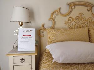 拉文纳Casa Aurora的床头灯和床头灯上的一张带标志的床