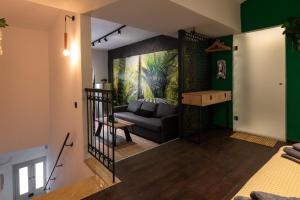 锡米Green Symi Apartment的客厅设有黑色沙发和绿色的墙壁。