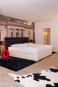 布伦瑞克豪斯楚汉萨同盟酒店的卧室配有一张白色大床和一幅画