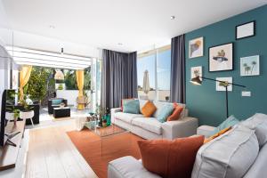 圣乌尔苏拉Home2Book Amazing Santa Úrsula, Sea Views & Terrace的客厅设有两张沙发和一堵蓝色的墙壁