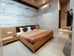 孟买Hotel Prasad NX的一间卧室配有一张床和一台电视
