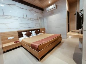 孟买Hotel Prasad NX的一间卧室配有一张大床和电视