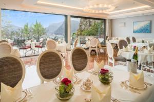 萨尔茨堡蒙切斯泰恩城堡酒店的餐厅设有白色的桌椅和大窗户