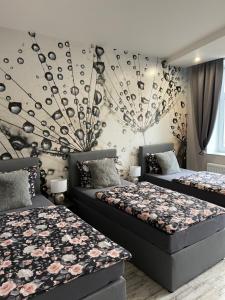 爱尔福特Ferienwohnungen in Erfurt的一间卧室设有两张床和鲜花墙
