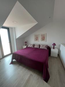 Rabo de Peixe克温塔桑塔纳酒店的一间卧室配有一张大紫色床和两盏灯