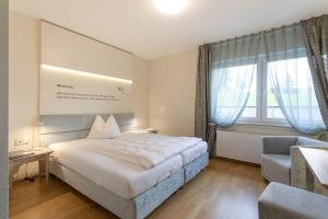 巴特拉斯费艾母奥尔巴赫特尔酒店的配有一张床和一把椅子的酒店客房