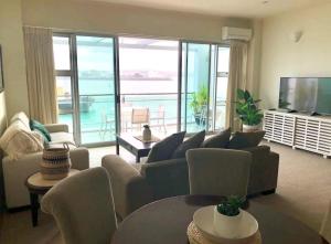 奥克兰Life on Water- Princes Wharf apartment with fabulous views的客厅配有沙发、椅子和电视